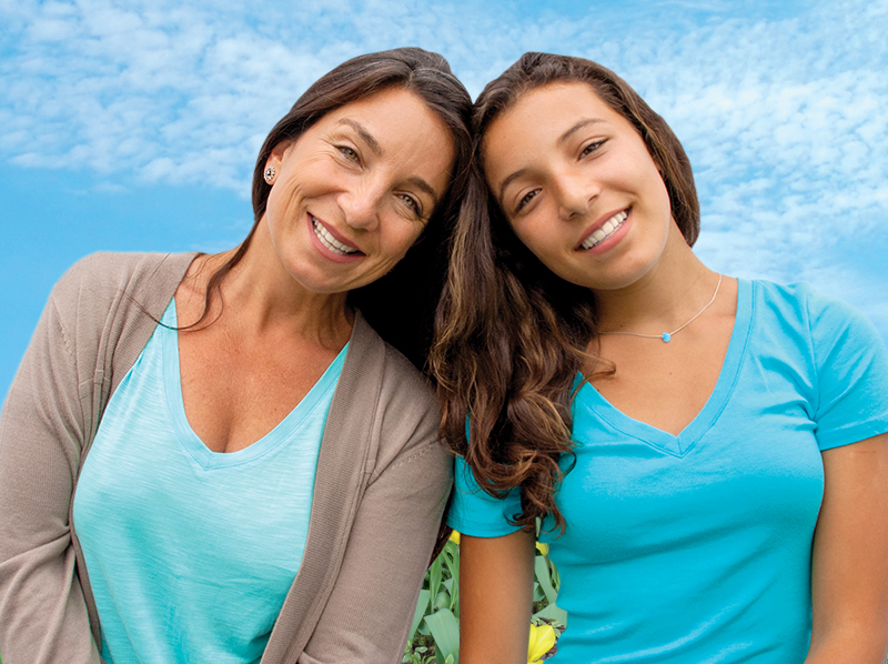 Parent and child smiling on the coast